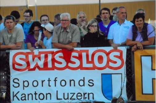 Zuschauer mit Logo Luzern und Swisslos. Spectateurs avec logo de Lucerne et de Swisslos. Spettatori con il logo di Lucerna e di Swisslos.